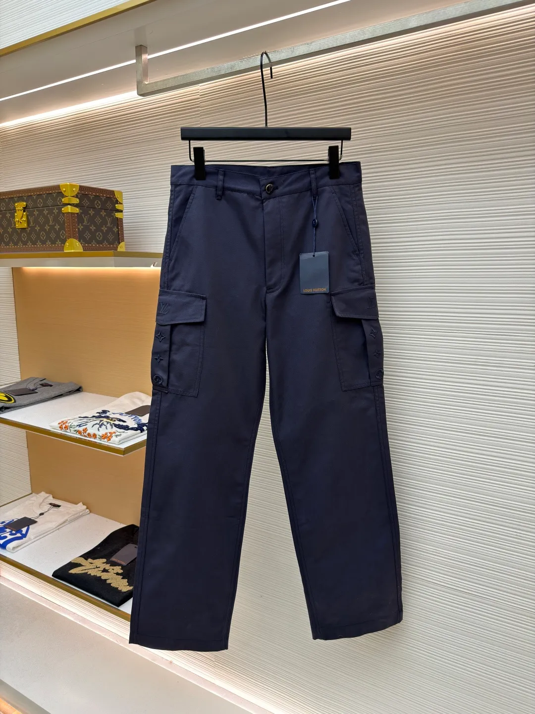 LOUIS VUITTON pocket embroidered work trousers ●Original version: Purchased and developed for 9999 ●Item number: 1681825-B50 ●Fabric: cotton twill fabric ●Technology: embroidery production ●Color: navy blue ●Version: fitted version ●Weight: about 520 grams ●Size: 44-46-48-50 ●Description: The high cotton content ensures the fabric's excellent breathability, durability and classic workwear texture, while the twill weave gives it unique wear resistance and stiffness. The special fabric technology solves the pain points of tight and stiff traditional overalls; it provides greater freedom when moving, significantly improves wearing comfort and flexibility, and achieves a balance between function and comfort. The application of three-dimensional core-spinning embroidery technology in the pocket position is achieved by adding additional cotton thread or foam as the core material to the pattern filling layer, and then using embroidery thread to fully cover the embroidery. The logo pattern is significantly protruded from the surface of the fabric, forming a full three-dimensional effect. This process not only enhances the visual impact and tactile level, but also improves the wear resistance of the pocket area through the buffering effect of the core material, ensuring that the pattern can still remain crisp and not deformed in complex daily use, ensuring that the pattern is clear and durable, and injecting a sense of sophistication into the rugged workwear style. Diversified pocket system combines workwear functionality with sophistication. The flap cargo pockets on both sides are a signature element, and their flap design prevents items from falling and enhances the visual three-dimensionality. Italian style pockets provide simple side storage. The overall wiring is straight and delicate, the fabric is comfortable and soft, and the color is consistent without color difference. It can be matched with the same style to create a fashionable look and control various occasions. Customized accessories, complete with three standards, same style for men and women!